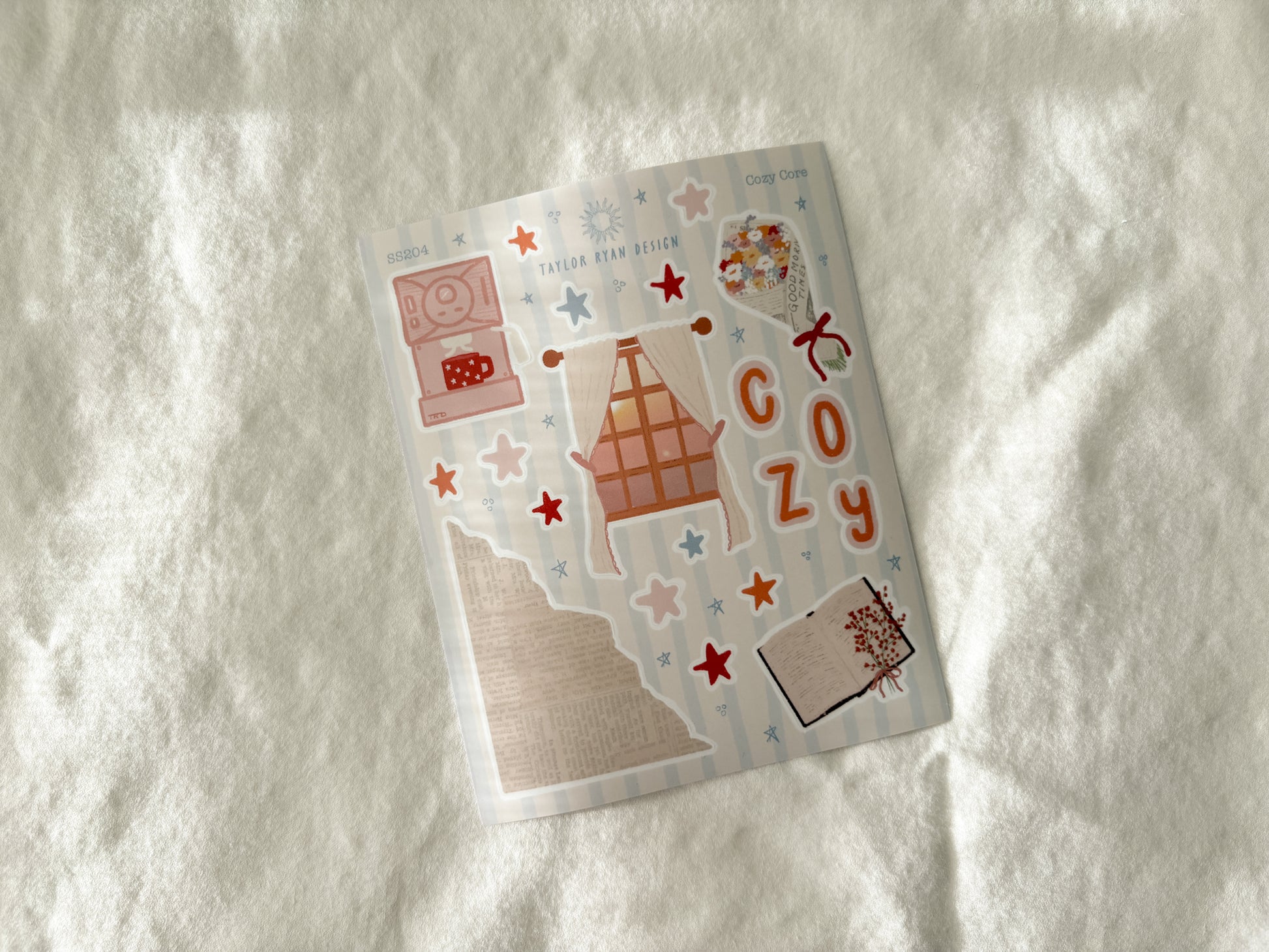 Sticker Sheet of decorative stickers with cozy-themed designs on a textured white surface